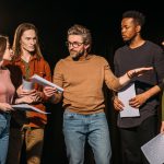 multiethnic actors and actresses rehearsing with theater director on stage
